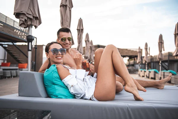 Casal positivo sorrindo enquanto posando para a câmera na praia — Fotografia de Stock