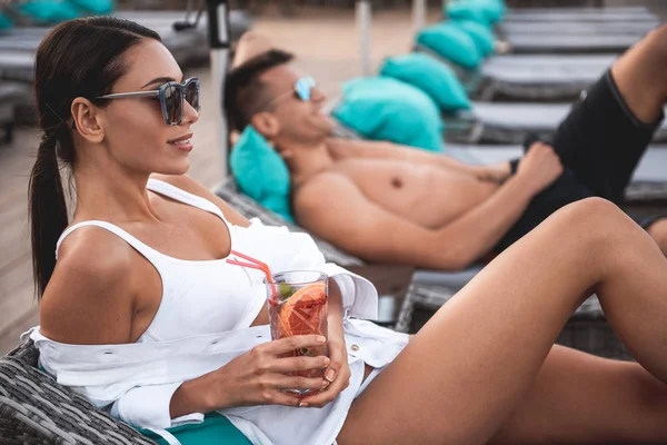 Calma joven mujer relajante en la silla de sol salón con cóctel — Foto de Stock