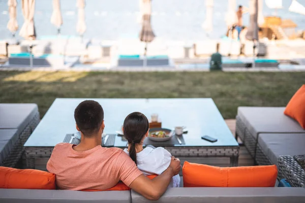 Mann und Frau umarmen sich auf der Terrasse und genießen die Aussicht im Resort — Stockfoto