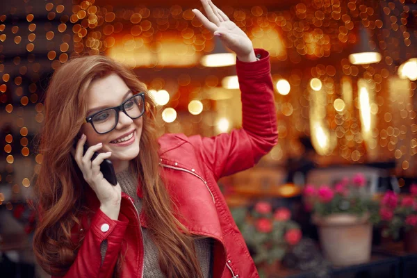 Attraktiva rödhåriga flickan talar i mobiltelefon och hälsning vän — Stockfoto