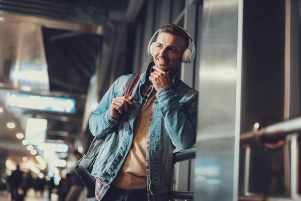 Hombre con auriculares mirando a un lado y disfrutando de la pista mp3 — Foto de Stock