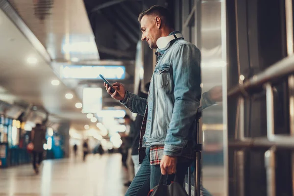 Homem atraente procurando informações sobre voar no telefone — Fotografia de Stock