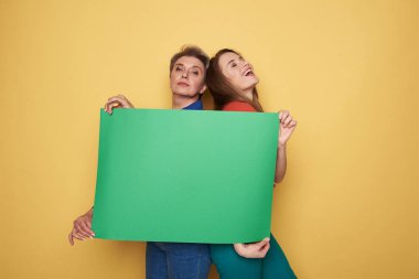 Kırpılmış yeşil boş poster studio holding beyaz kadın fotoğrafı