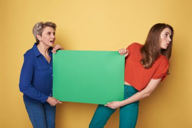 Kırpılmış yeşil ağır boş poster studio holding beyaz kadın fotoğrafı