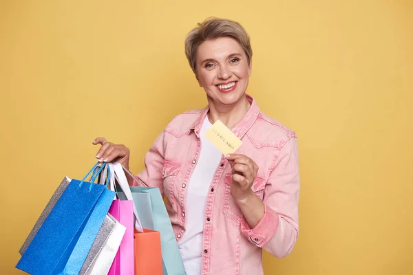 Cintura hacia arriba de la mujer feliz sosteniendo coloridas bolsas de compras y tarjeta de oro —  Fotos de Stock