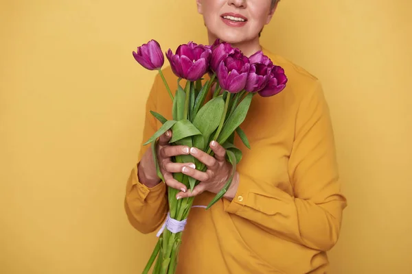 Foto recortada de mulher caucasiana com bonito buquê de tulipas nos braços — Fotografia de Stock