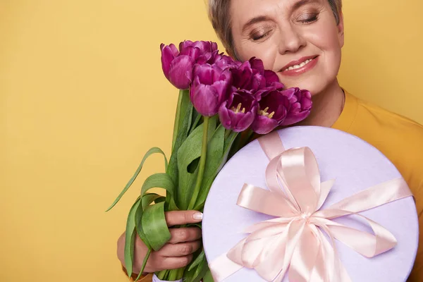 Портрет щасливої чарівної жінки з букетом фіолетових тюльпанів на руках — стокове фото