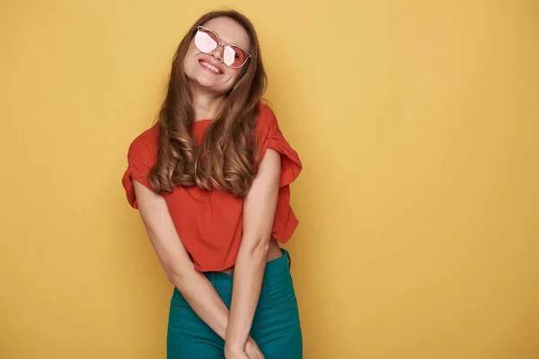 Taille van lachende brunette jonge dame in brillen poseren voor de camera — Stockfoto