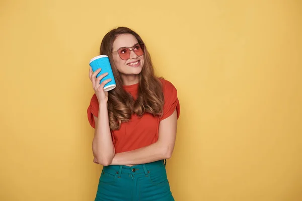 オレンジ色の背景に対して腕で女の子維持 cupholder を笑顔の上半身 — ストック写真