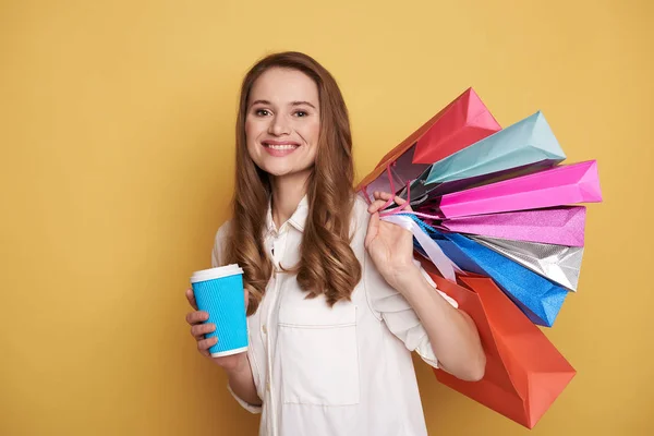 Талія красивої щасливої молодої жінки, насолоджуючись покупками та напоями — стокове фото