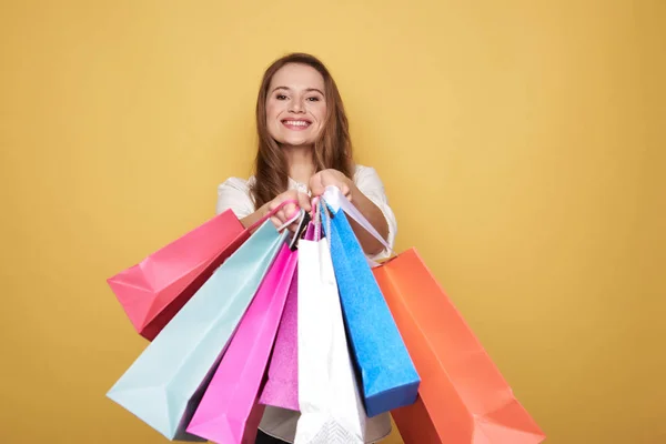 Tour de taille de fille heureuse caucasienne montrant des sacs à provisions pour appareil photo — Photo