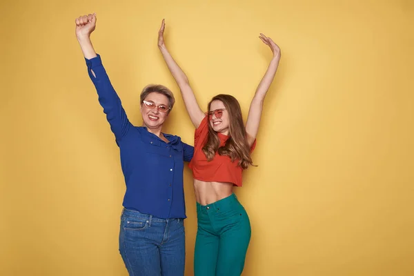 Waist up of happy Caucasian women raising their hands up