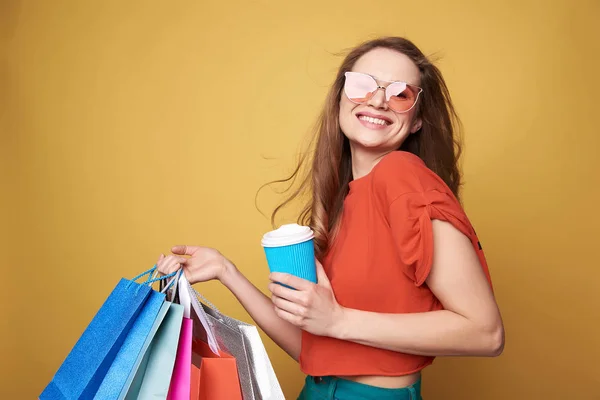 Bajo ángulo de sonriente morena joven bebiendo café después de ir de compras — Foto de Stock