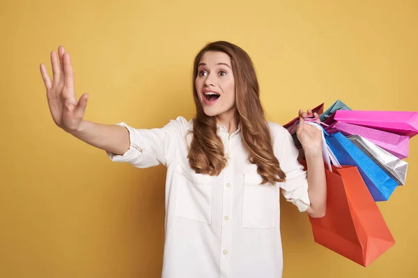 Cintura hacia arriba de la joven sorprendida sosteniendo bolsas de compras y la captura de taxi —  Fotos de Stock