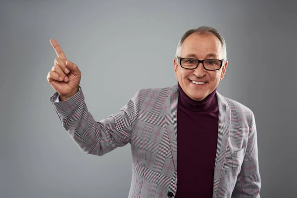 Hombre feliz sonriendo mientras señala con el dedo hacia arriba — Foto de Stock