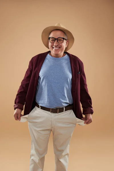 Hombre optimista que no tiene nada en los bolsillos y sonríe — Foto de Stock