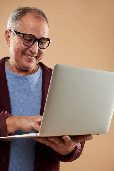 Крупним планом усміхнений чоловік в окулярах дивиться на екран свого ноутбука — стокове фото