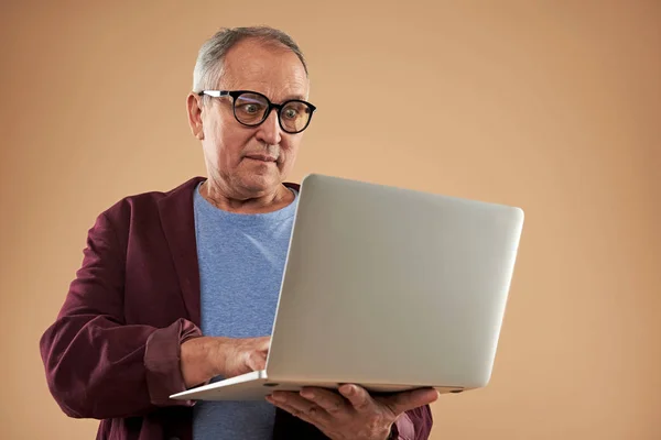 Вражений дорослий чоловік уважно дивиться на екран ноутбука — стокове фото