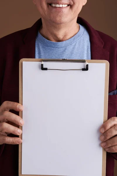 Пустой лист бумаги на планшете в руках улыбающегося человека — стоковое фото