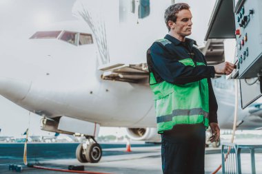 Büyük uçak yakınındaki Tekdüzen ayakta ciddi yakışıklı adam