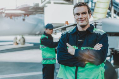 Aerodrom içinde ayakta gülümseyen yakışıklı işçi