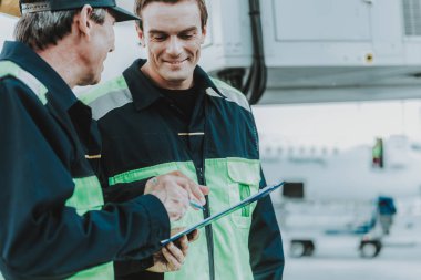 Bir şey genç meslektaşına açıklayan tecrübeli adam