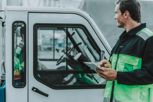 Handsome worker looking at the transport on the workplace