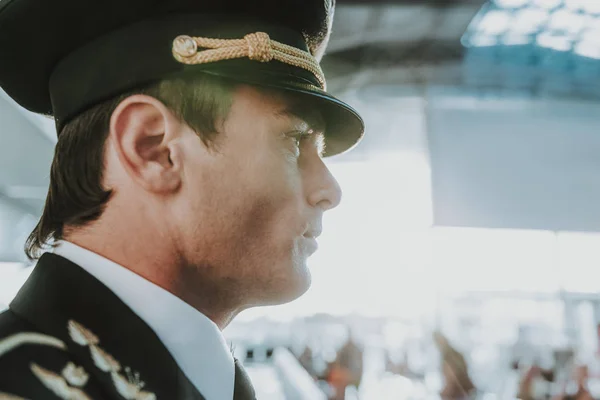Schöner junger Pilot steht auf dem Flughafen — Stockfoto