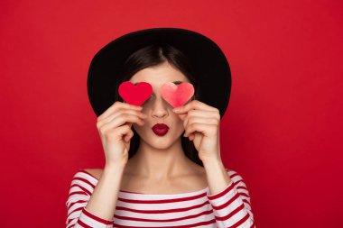 Kırmızı kağıt kalpleri tarafından gözleri kapanış Coquettish kız