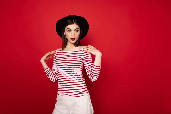 Überraschte Mädchen in gestreifter Bluse und schwarzem Hut — Stockfoto