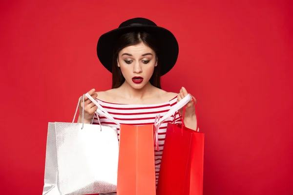 Elegante dama sorprendida mirando en paquetes de compras — Foto de Stock