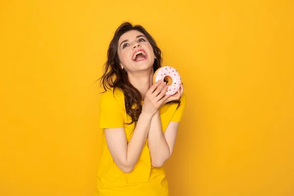 Glücklich lachendes Mädchen mit süßem Donut in der Hand — Stockfoto