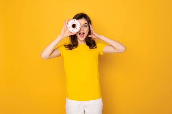 Menina rindo feliz olhando do buraco de donut — Fotografia de Stock