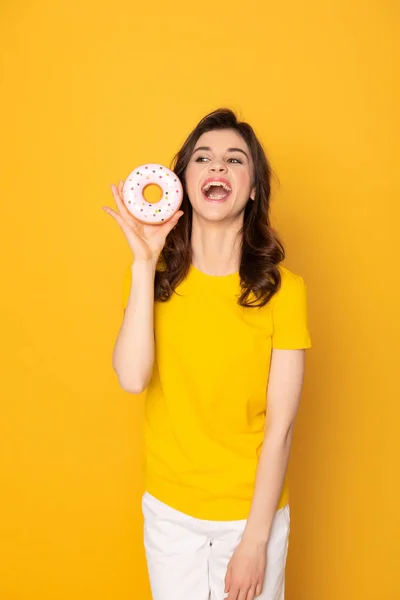 Glücklich aufgeregtes Mädchen mit süßem Donut in der Hand — Stockfoto