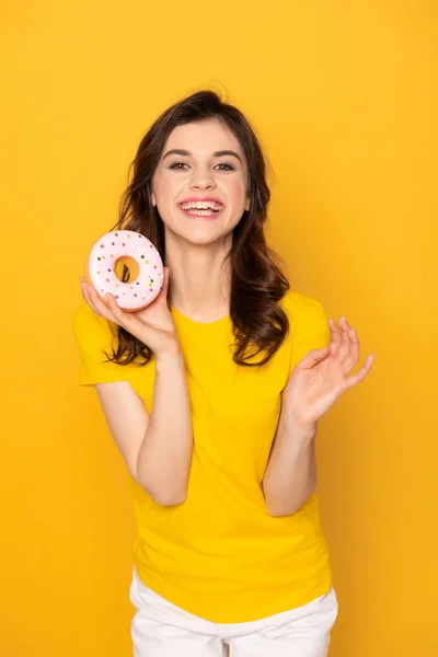 Glücklich aufgeregtes Mädchen zeigt süßen Donut in der Hand — Stockfoto