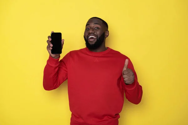 Taille up van glimlachende Afrikaanse man met smartphone in armen — Stockfoto