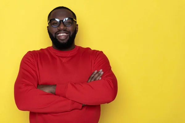 Media longitud de hombre africano feliz con las manos cruzadas posando en el estudio — Foto de Stock