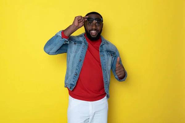 Cintura para arriba del hombre africano alegre que se quita las gafas en el estudio — Foto de Stock