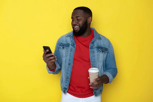 Taille up van glimlachende Afrikaanse man houden beker en smartphone in armen — Stockfoto