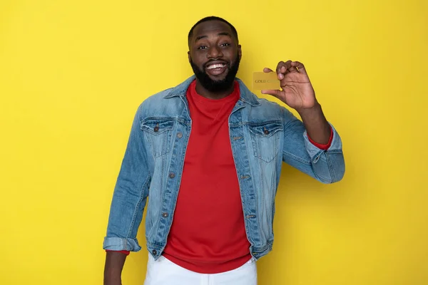Taille up van glimlachende Afrikaanse man houden gouden kaart in armen — Stockfoto