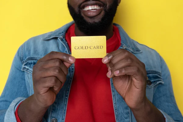 Bijgesneden foto van Afrikaanse man houden gouden kaart in armen — Stockfoto