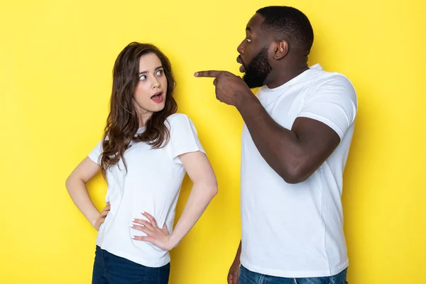 Stressato giovane coppia interrazziale in bianco T-shirt in posa per la fotocamera in studio — Foto Stock