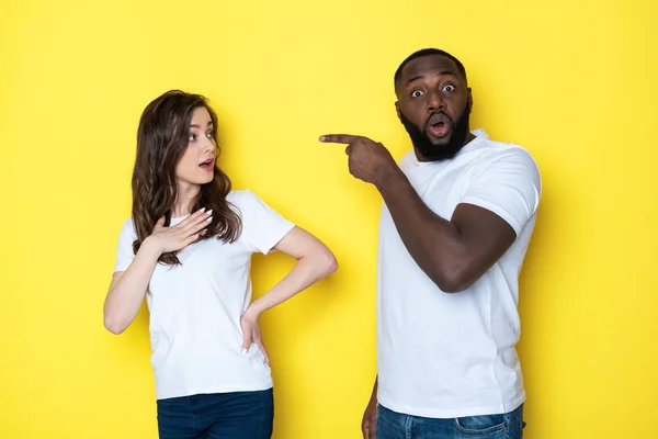 Stressé jeune couple interracial en blanc T-shirts posant pour caméra en studio — Photo