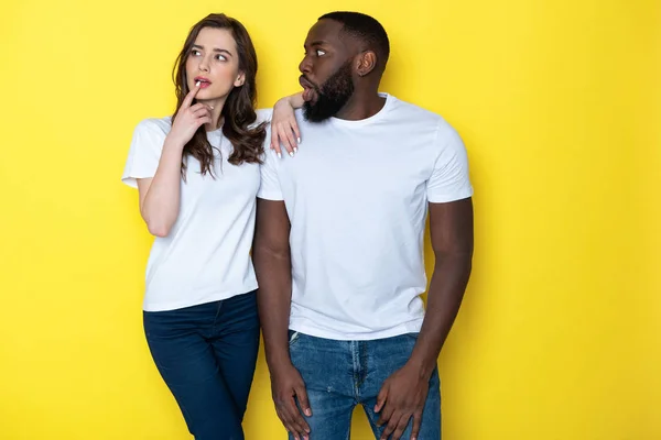Giovane coppia interrazziale in bianco T-shirt in posa per la fotocamera in studio — Foto Stock