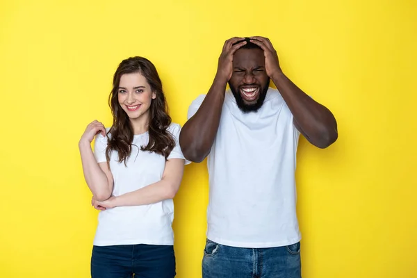 Souriant couple interracial chanceux en blanc T-shirts posant pour caméra en studio — Photo