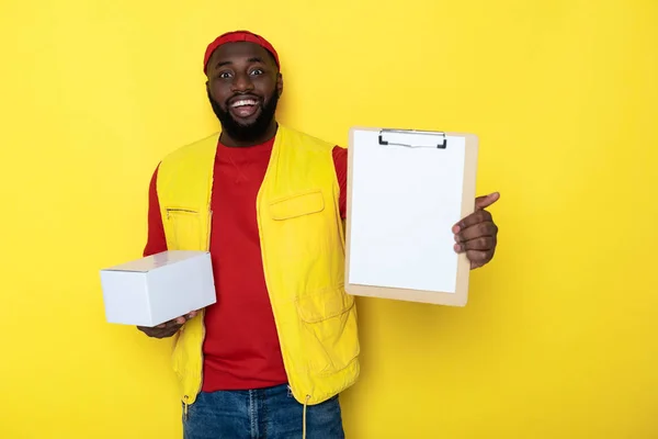 Halve lengte van Afrikaanse man Holding Klembord en levering tegen gele achtergrond — Stockfoto