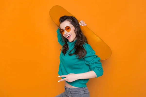 Cintura de menina branca elegante posando para câmera com skate — Fotografia de Stock