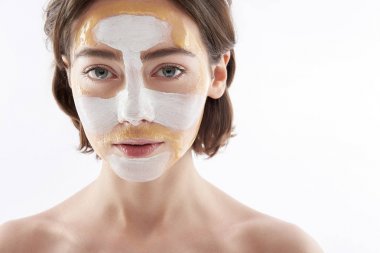 Yüzünde maske olan sakin esmer bir kadın.