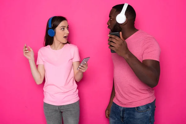 Poloviční délka mladého interrasového páru, který nosí moderní sluchátka ve studiu — Stock fotografie