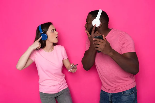 Demi-longueur de jeune couple interracial portant des écouteurs modernes en studio — Photo
